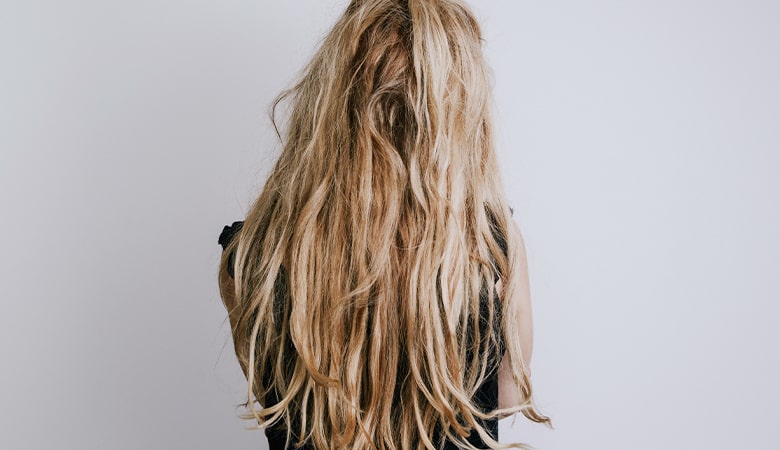 Kobieta z długimi i zniszczonymi włosami - zdjęcie.