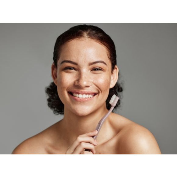 Uśmiechnięta kobieta ze szczoteczką do zębów