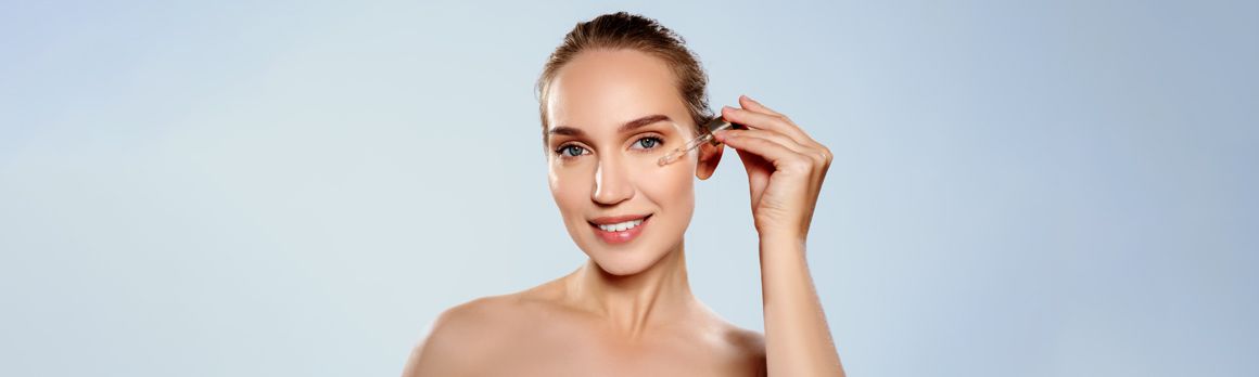 Kobieta nakładająca pipetką serum na twarz - tytułowa