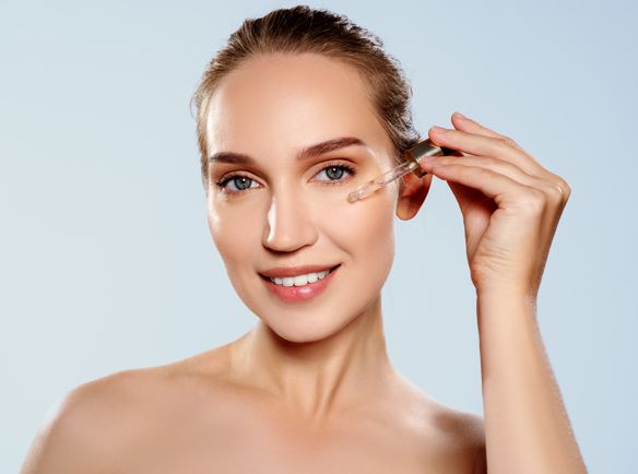 Kobieta nakładająca pipetką serum na twarz - tytułowa