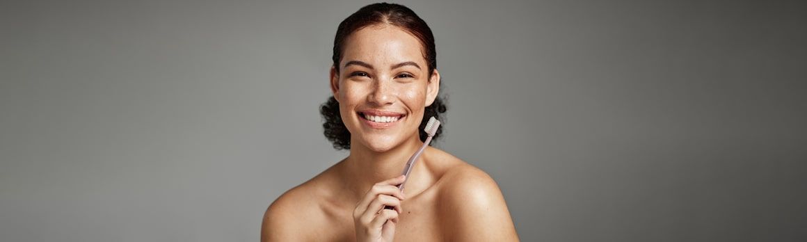 Uśmiechnięta kobieta ze szczoteczką do zębów