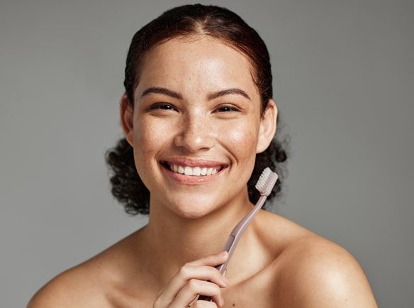 Uśmiechnięta kobieta ze szczoteczką do zębów