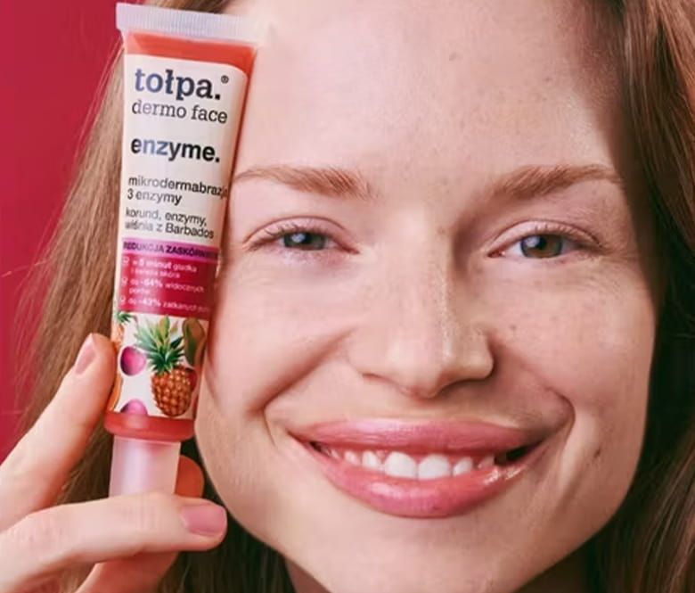 tołpa® dermo face enzyme. mikrodermabrazja 3 enzymy - kobieta trzymająca kosmetyk przy twarzy - zdjęcie
